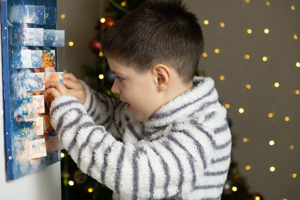 A child reaching into a Christmas advent calendar